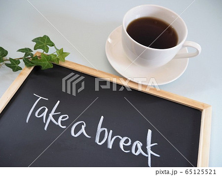 コーヒーの入った白いカップと"Take a break"というメッセージが書かれた黒板 65125521