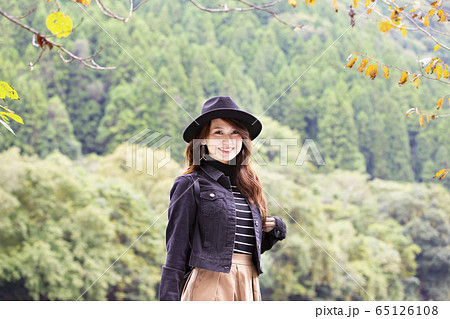 兵庫県武田尾廃線跡のハイキングコースを散策する帽子をかぶつた笑顔の若い女性 65126108