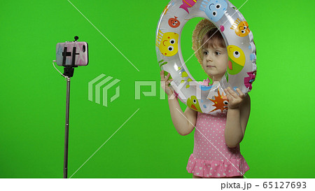 Girl child makes selfie vlog, blogging, video call on mobile phone. Vacation sea Girl child makes selfie vlog, blogging, video call on mobile phone. Vacation sea 65127693