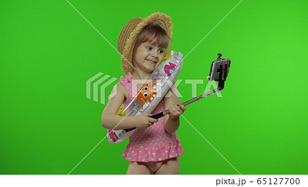 Girl child makes selfie vlog, blogging, video call on mobile phone. Vacation sea 65127700