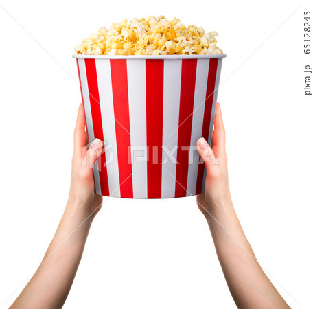 Woman holding striped popcorn bucket with two hands isolated on white background Woman holding striped popcorn bucket with two hands isolated on white background 65128245
