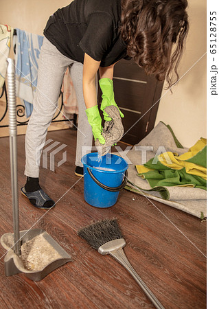 The girl washes the floor with a rag in the room The girl washes the floor with a rag in the room 65128755