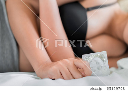 Young asian women holding and show a condom in her 65129798