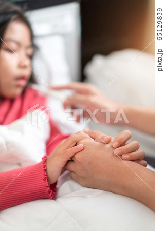 Asian mother touch hand young daughter for 65129839
