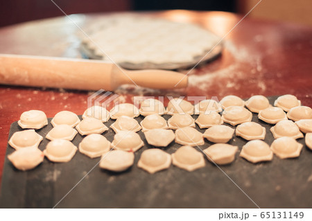 Cooking dumplings. Rows of raw dumplings and 65131149