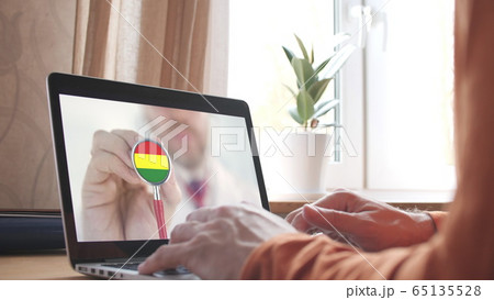 Doctor's video call on the laptop at home, stethoscope bell with the Bolivian flag. Telemedicine in Bolivia Doctor's video call on the laptop at home, stethoscope bell with the Bolivian flag. Telemedicine in Bolivia 65135528