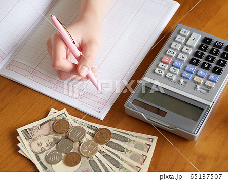 お小遣い帳に記入する女性のイメージ 65137507