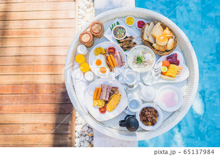 Floating breakfast set in tray with fried egg omelette sausage ham bread fruit milk juice coffee Floating breakfast set in tray with fried egg omelette sausage ham bread fruit milk juice coffee 65137984