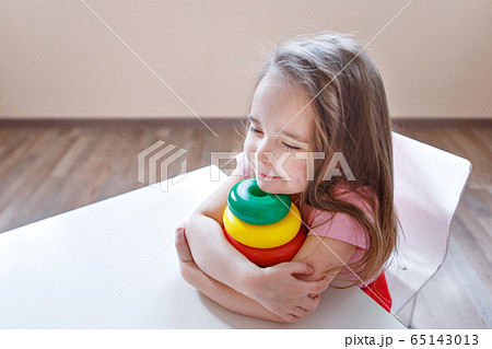 the child collects a pyramid. Details of the toy in the hands. Concept of development of fine motor skills, educational games, childhood, IVF, children's day, kindergarten copy space 65143013