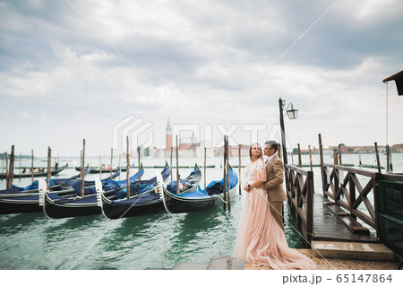 Wedding couple on the nature is hugging each other. Beautiful model girl in white dress. Man in suit.Venice, Italy Wedding couple on the nature is hugging each other. Beautiful model girl in white dress. Man in suit.Venice, Italy 65147864