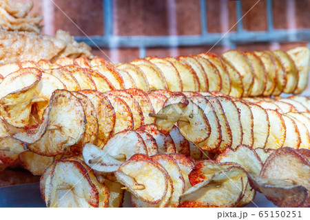 Round potato chips skewered outside on a bright 65150251