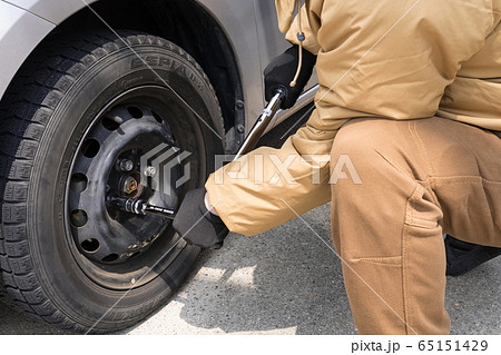 タイヤ交換 トルクレンチでボルトを締める作業員の写真素材