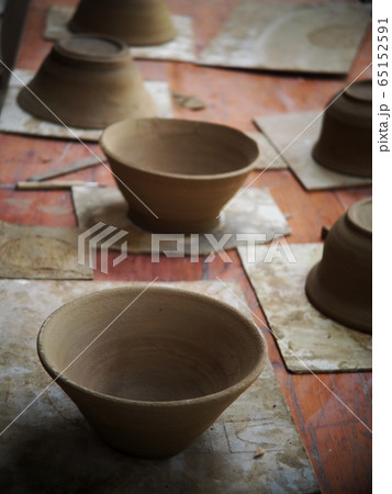 round soft brown color formed clay for ceramic utensils bowls under production process in a factory after throwing process leaving to dried out and prepare to burn in kiln. 65152591