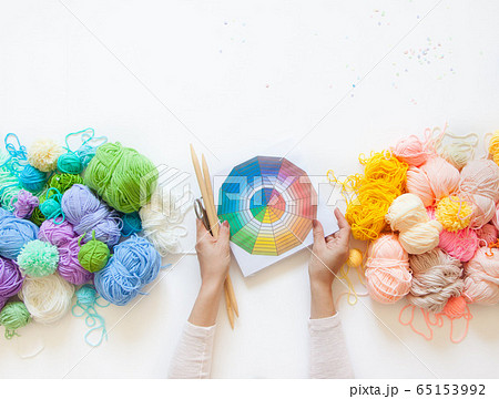 Yarn for knitted warm and cold shades. Female hands hold a color wheel. White background. Yarn for knitted warm and cold shades. Female hands hold a color wheel. White background. 65153992