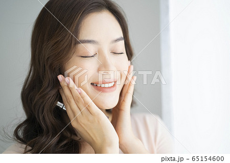 化粧品を手に持つ女性のポートレート 化粧品を手に持つ女性のポートレート 65154600
