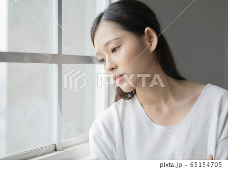 窓辺にいる真顔の女性 65154705