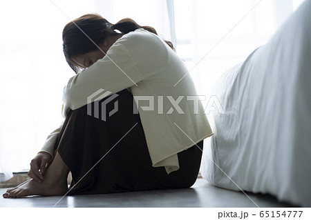 床に座って落ち込む女性 65154777