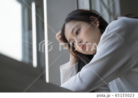 窓辺で悩み事をする女性 65155023