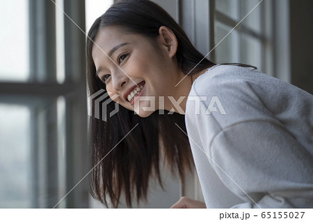窓から景色を見る若い女性の写真素材