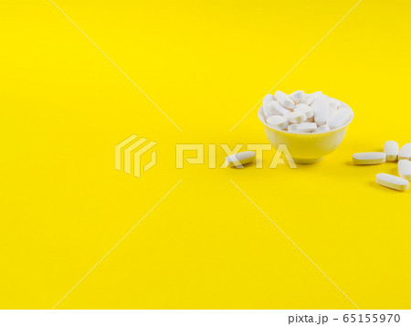 White magnesium citrate pills on yellow background White magnesium citrate pills on yellow background 65155970