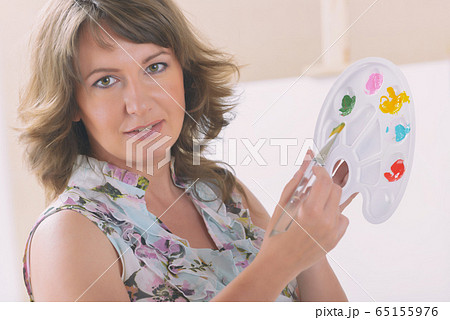 Woman artist holding palette with different paints Woman artist holding palette with different paints 65155976