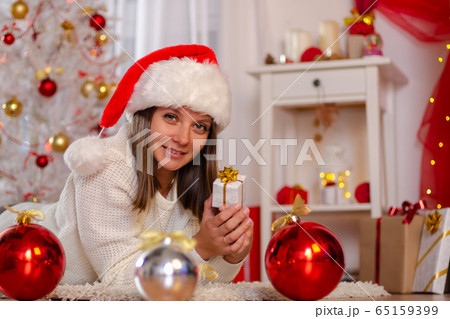 Happy girl in Christmas dress lies on the floor 65159399