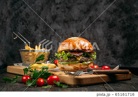 Closeup burger, fries and tomatoes Closeup burger, fries and tomatoes 65161716