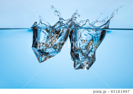 Abstract, minimalistic splash of water with ice cubes. Bubbles on a blue background. 65161997