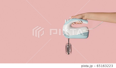 Millennial girl holding electric mixer on pink background, closeup. Empty space. Panorama 65163223