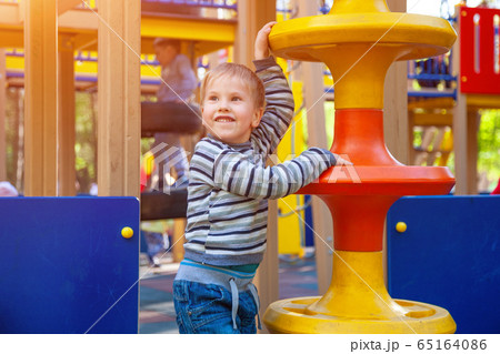 Cheerful boy playing on the Playground Cheerful boy playing on the Playground 65164086