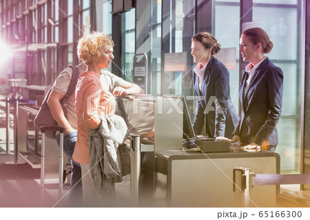 Portrait of mature couple asking airport staff Portrait of mature couple asking airport staff 65166300