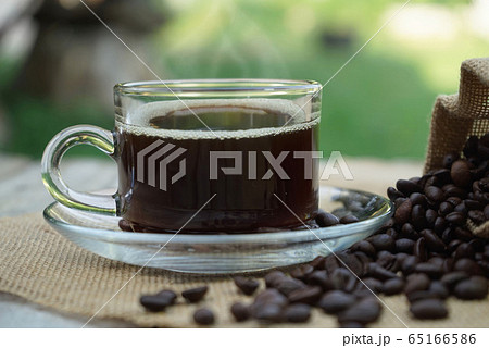Hot Coffee cup and coffee beans roating on the 65166586