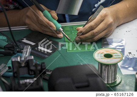 The skill operator soldering the PCB board . The skill operator soldering the PCB board . 65167126