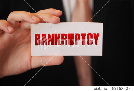 Bankruptcy on a card. Businessman holding a card with word Bankruptcy. Crisis business closing debts loss financial fiasko concept 65168288
