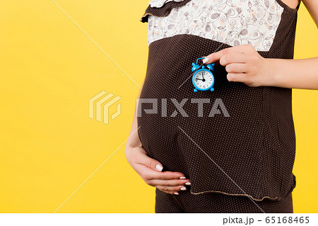 Close up of pregnant woman in brown pajamas 65168465