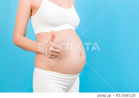 Cropped shot of positive pregnant woman in white Cropped shot of positive pregnant woman in white 65168520