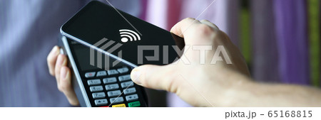 Hand holds out terminal for credit card payment 65168815