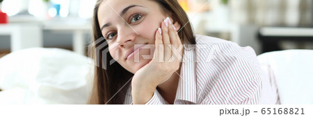 At home on bed lies cheerful girl in pajamas 65168821