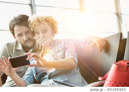 Portrait of mature couple taking selfie while 65169303