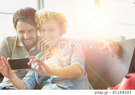 Portrait of mature couple taking selfie while 65169305