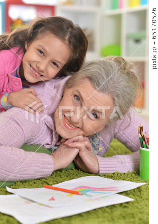 Portrait of grandmother and granddaughter drawing together Portrait of grandmother and granddaughter drawing together 65170526
