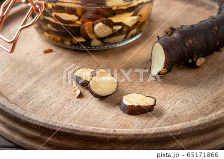 Cutting up fresh comfrey root to prepare tincture Cutting up fresh comfrey root to prepare tincture 65171866