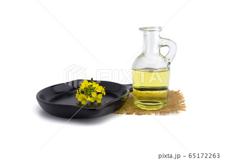 Yellow mustard flowers with decanter of oil 65172263