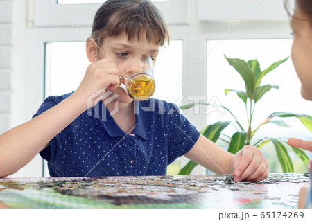 Girl drinks water playing board games at the table 65174269