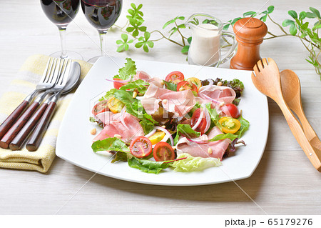 生ハム（イタリア産パンチェッタ、生ベーコン、豚肉生ハム）とベビーリーフ、ミニトマトのサラダ。赤ワイン 65179276