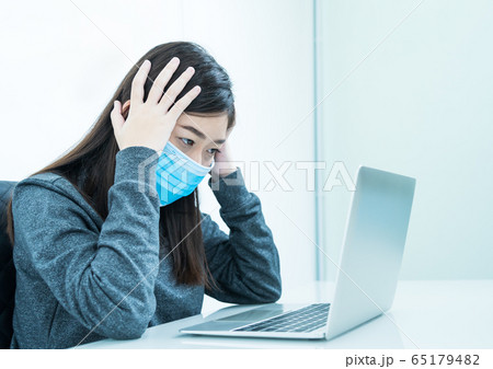 Woman using laptop on desk with headache wearing 65179482