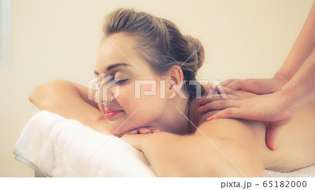 Woman gets back massage spa by massage therapist. 65182000