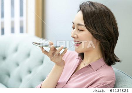 スマートフォンに音声入力をする女性 65182321