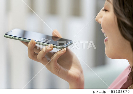 スマートフォンに音声入力をする女性 65182376