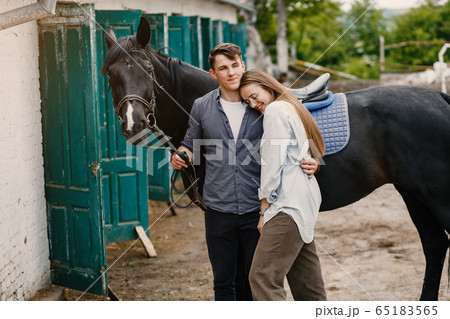 Cute loving couple with horse on ranch Cute loving couple with horse on ranch 65183565